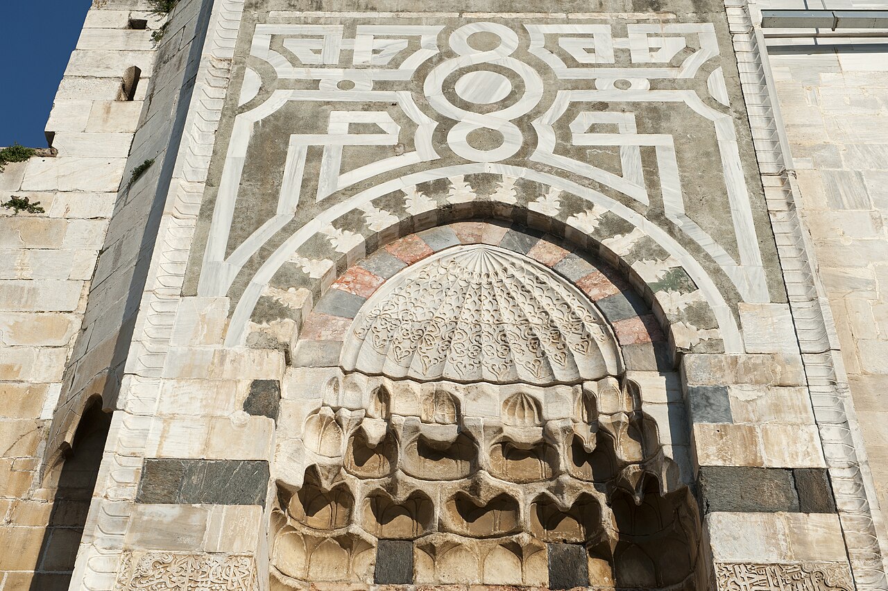 Geometric stonework and carved details above the monumental entrance of Isa Bey Mosque